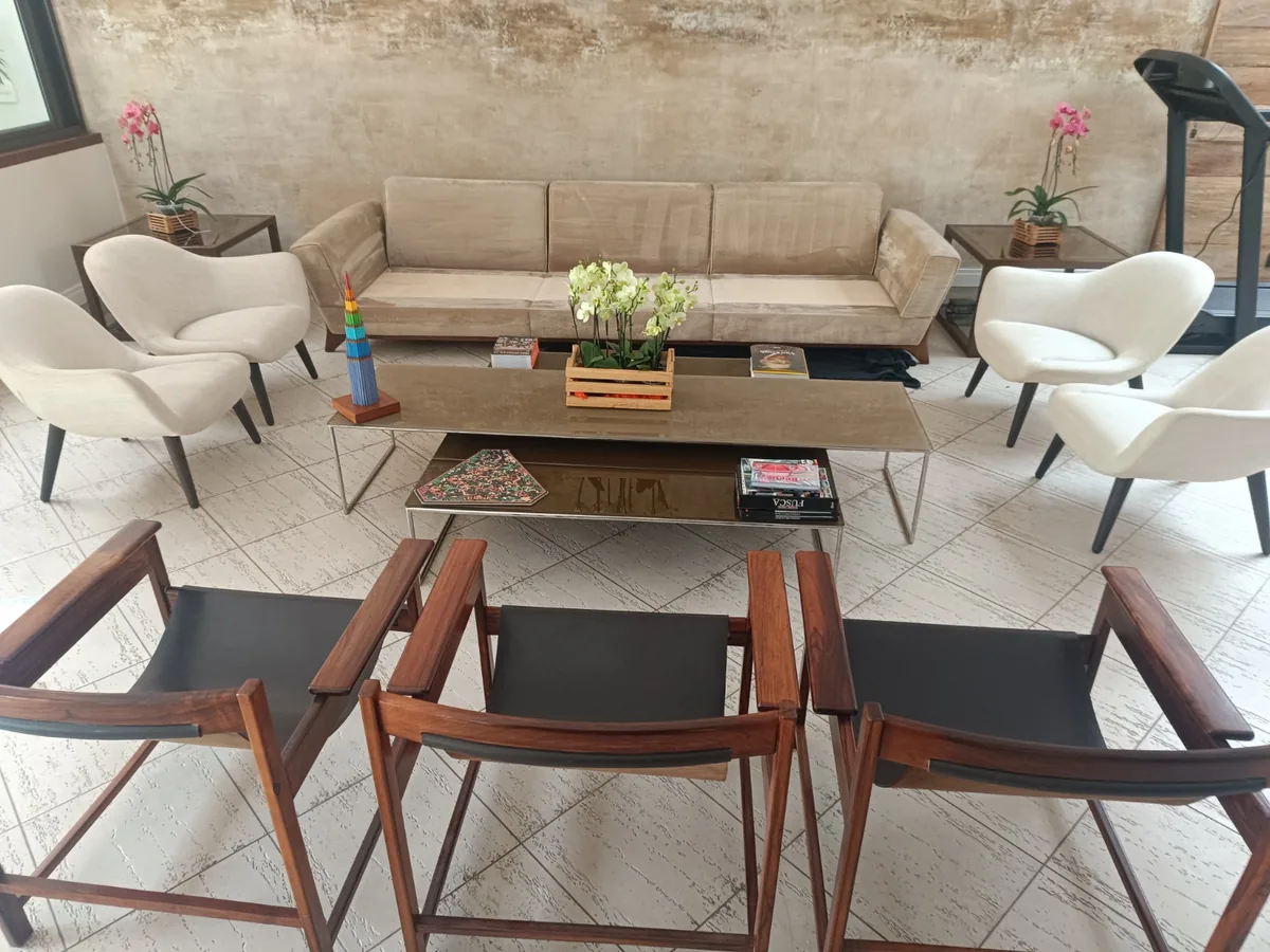 Sala ampla com poltronas brancas e cadeiras de design