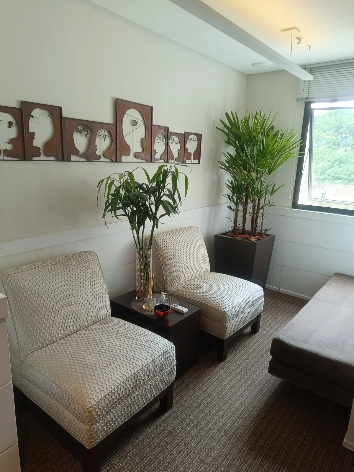 Poltronas claras com plantas junto à janela