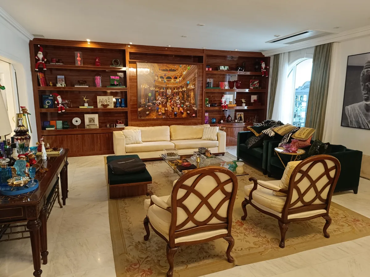 Sala clássica com estante e poltronas entalhadas