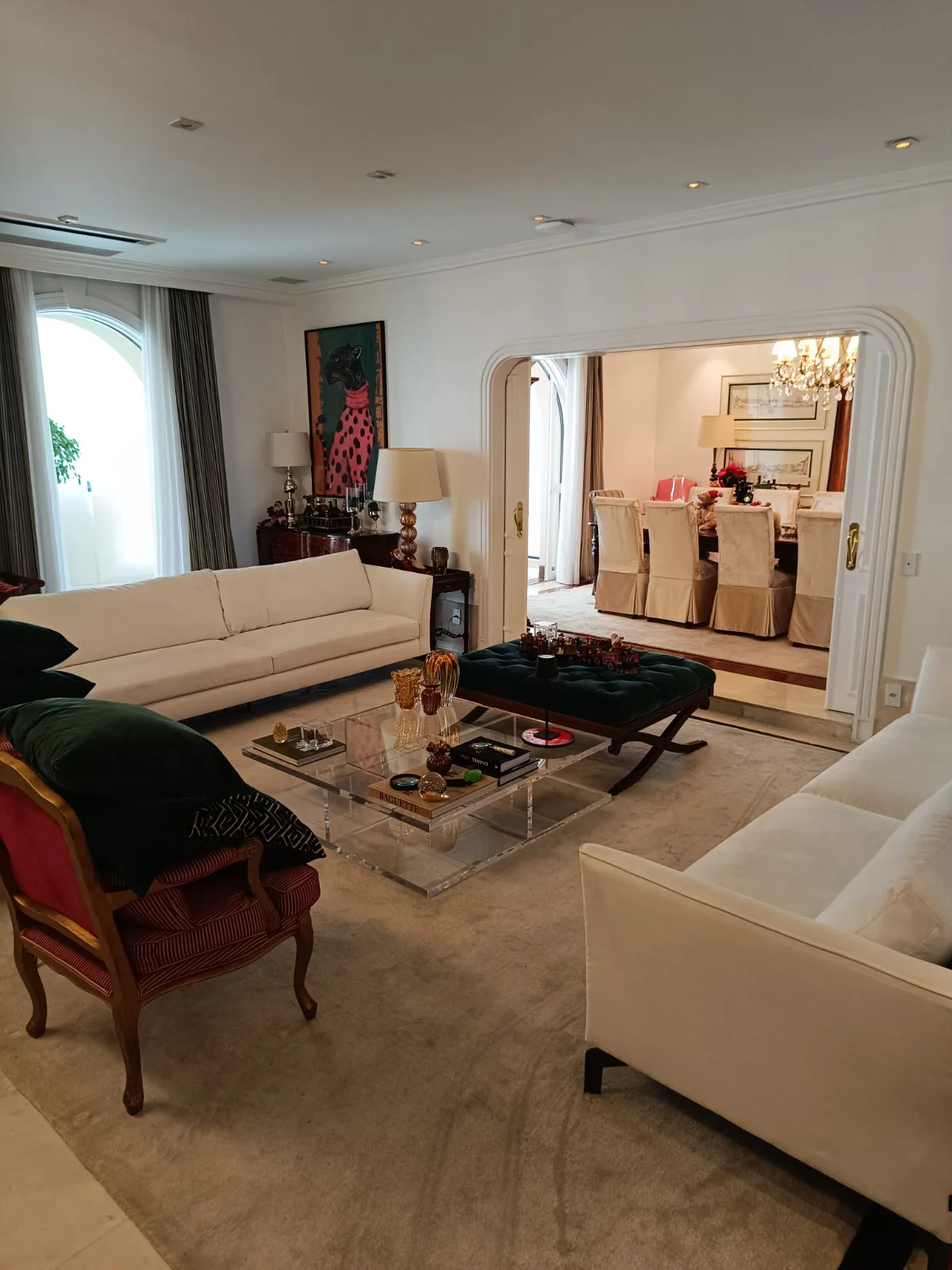 Sala ampla com arco e sofás brancos
