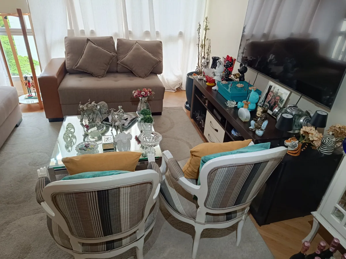 Living com cadeiras listradas e mesa de centro de vidro
