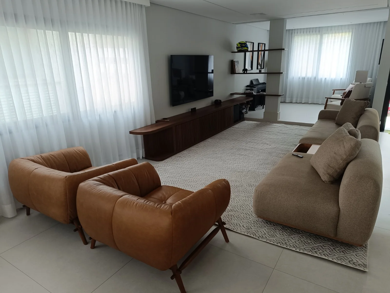 Poltronas de couro e sofá bege em sala clara