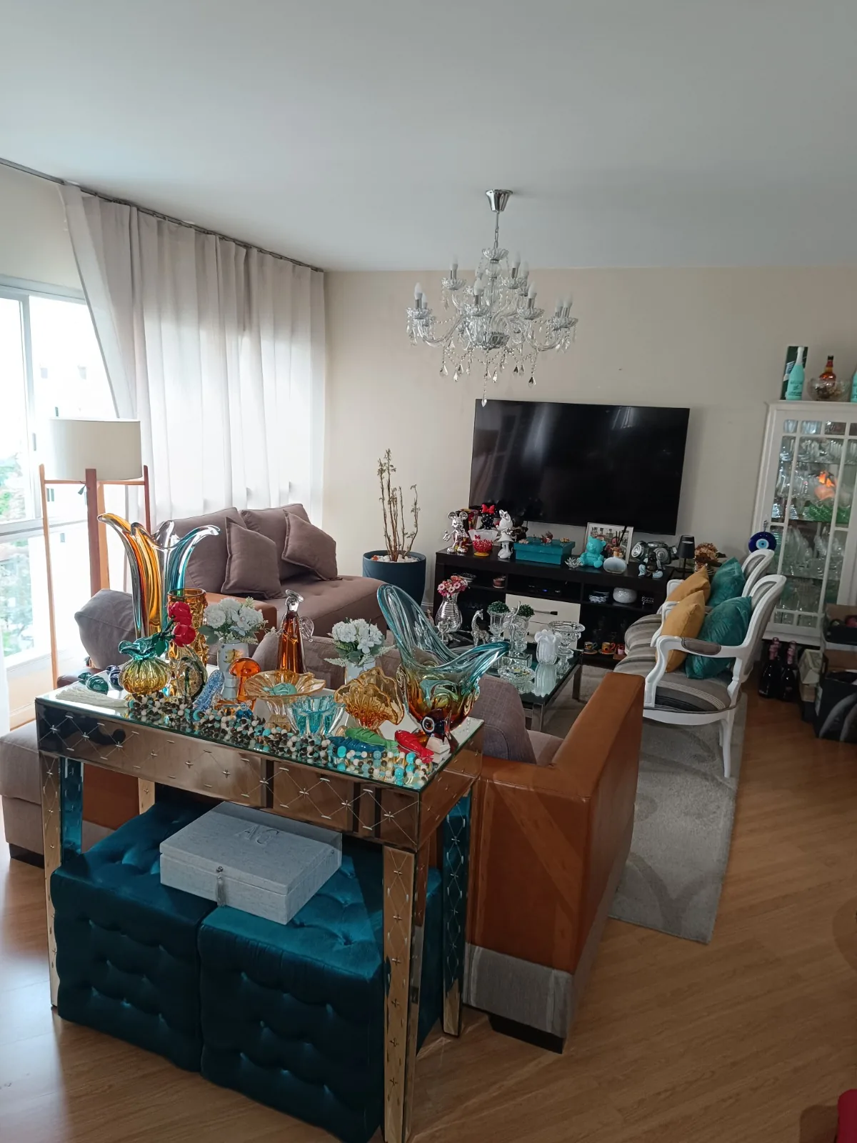 Sala decorada com aparador espelhado e poltronas
