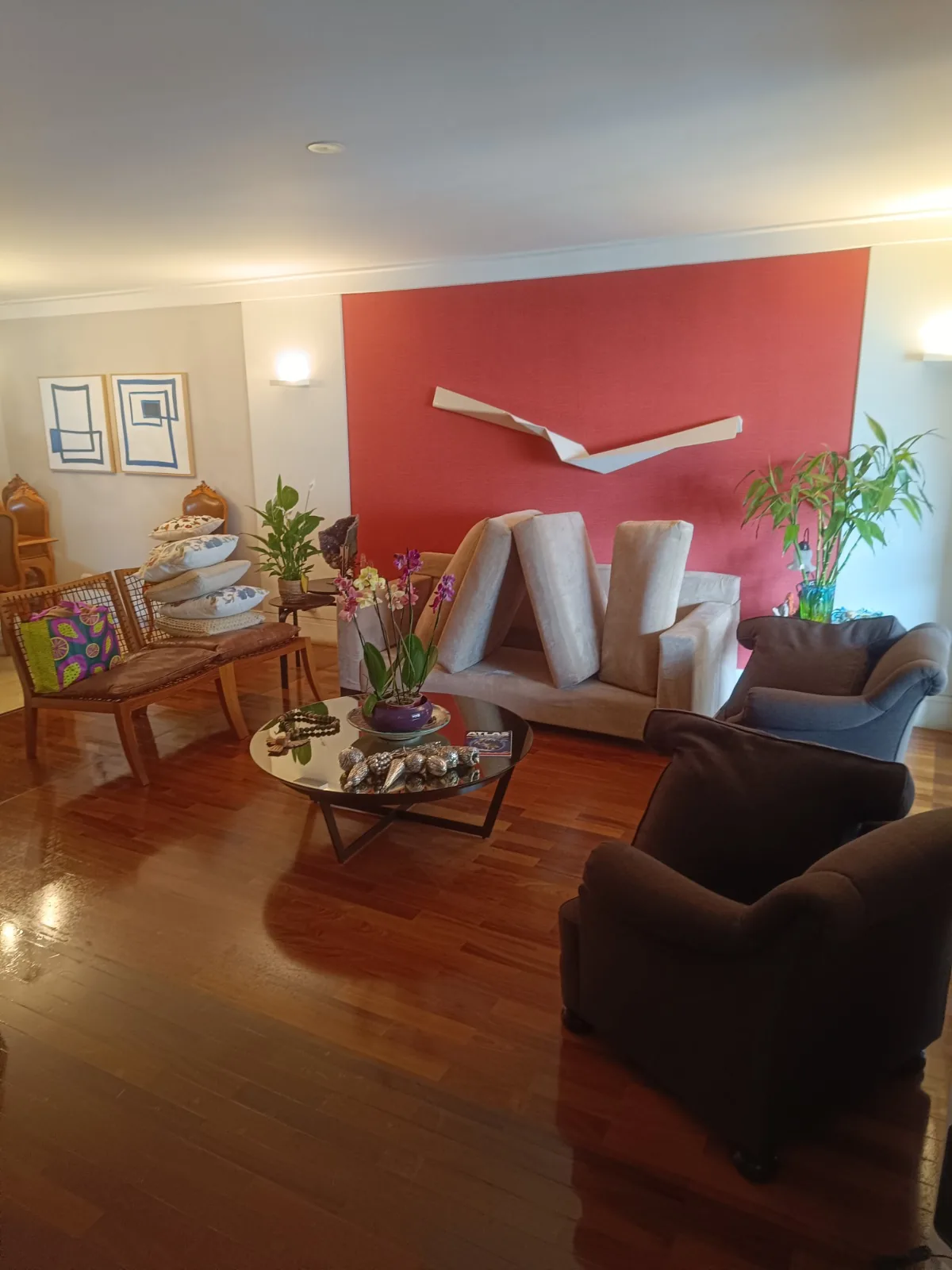 Sala com parede vermelha e poltronas marrons