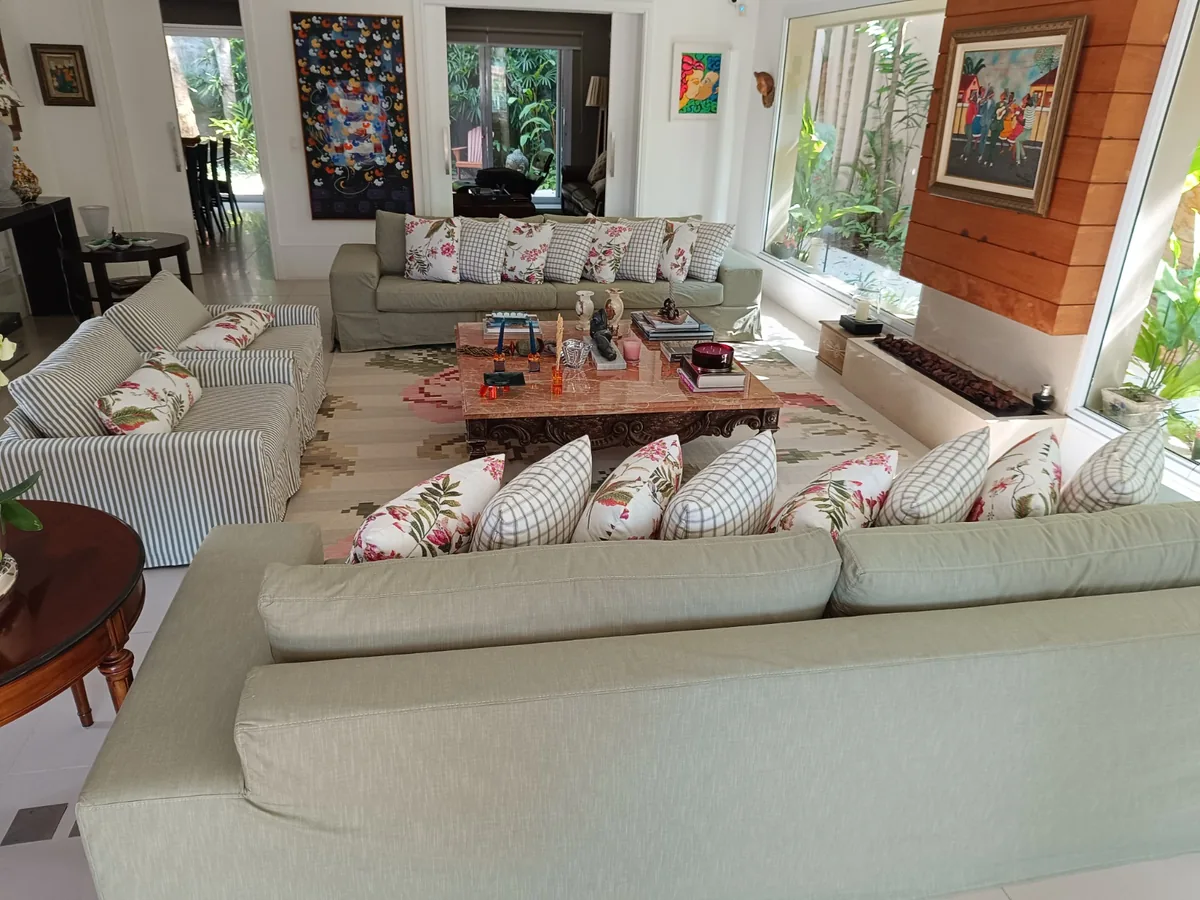 Sofá bege com almofadas estampadas em sala ampla