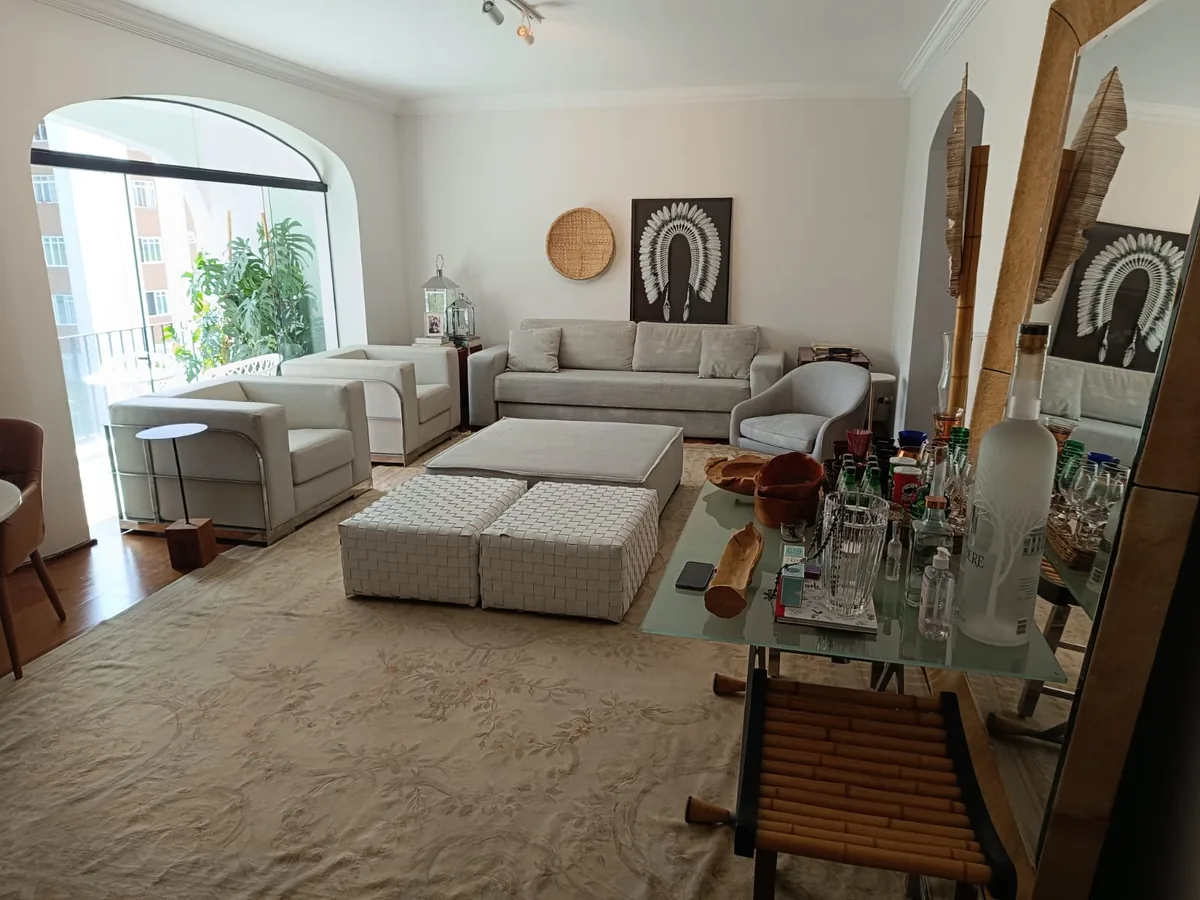 Sala clara com arco, sofá bege e tapete