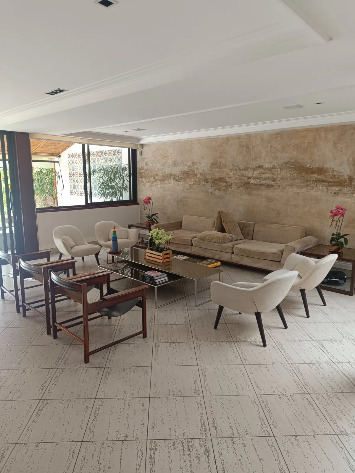 Sala ampla e clara com parede de travertino